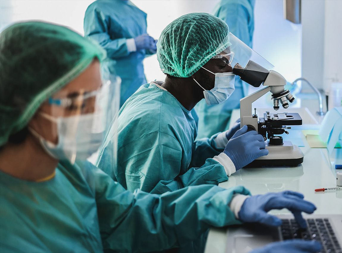 People in lab coat analysing a sample. 