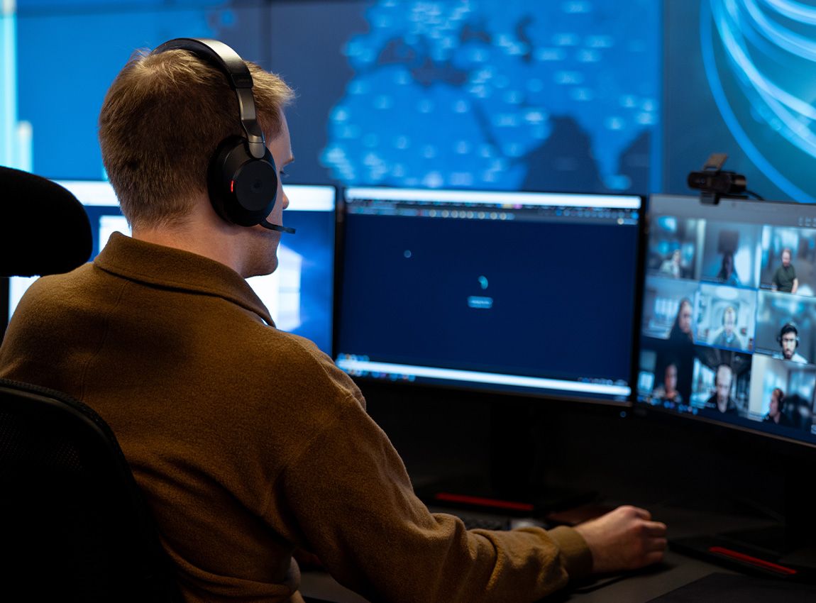 Man with headphones in a Teams call, solving support inquiries.