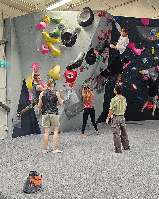 People climbing a wall at a indoors climbing gym